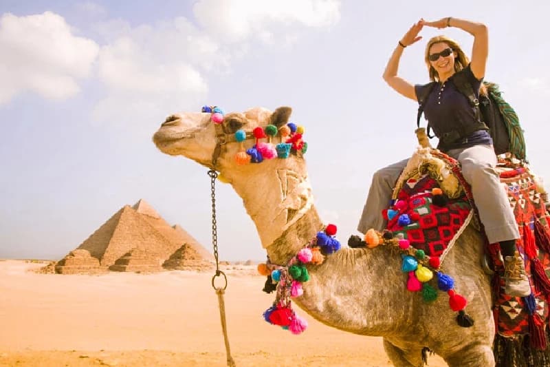 una donna sul cammello nelle piramidi , vacanza di natale in egitto